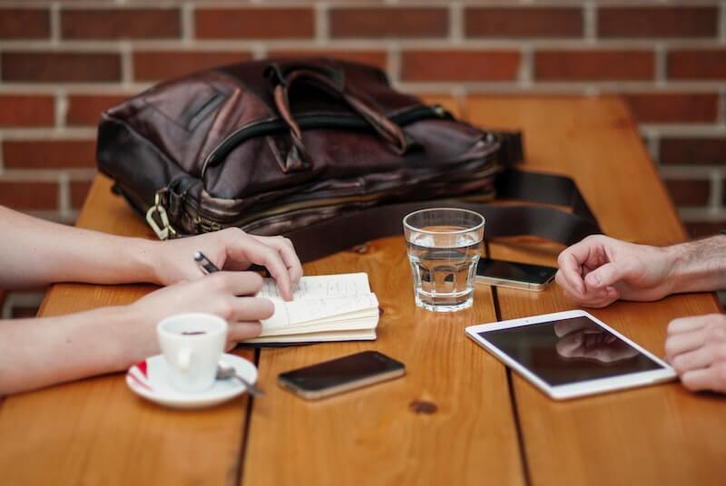 mesa con cafe movil cartera manos