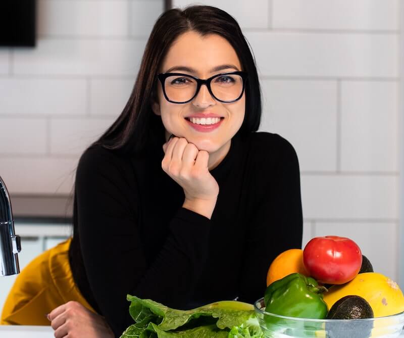 chica morena gafas sonríe frutas y verduras