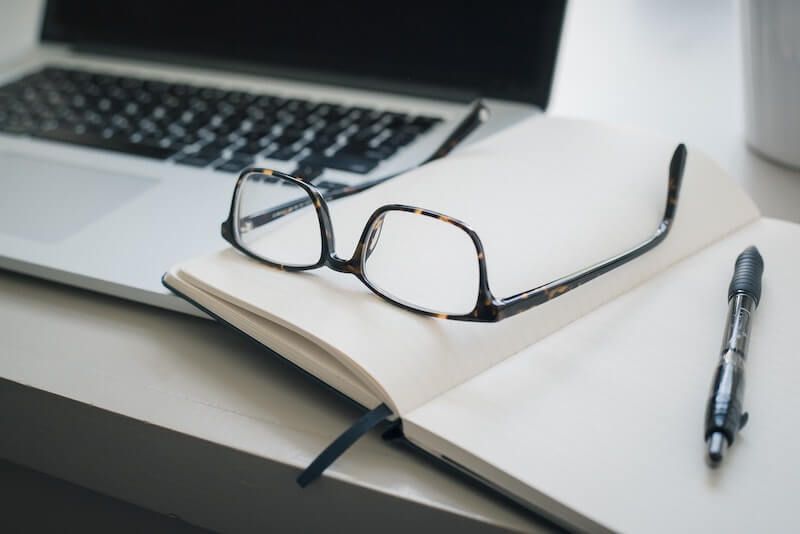 gafas sobre libreta y laptop