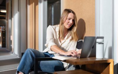 chica joven rubia con laptop al sol