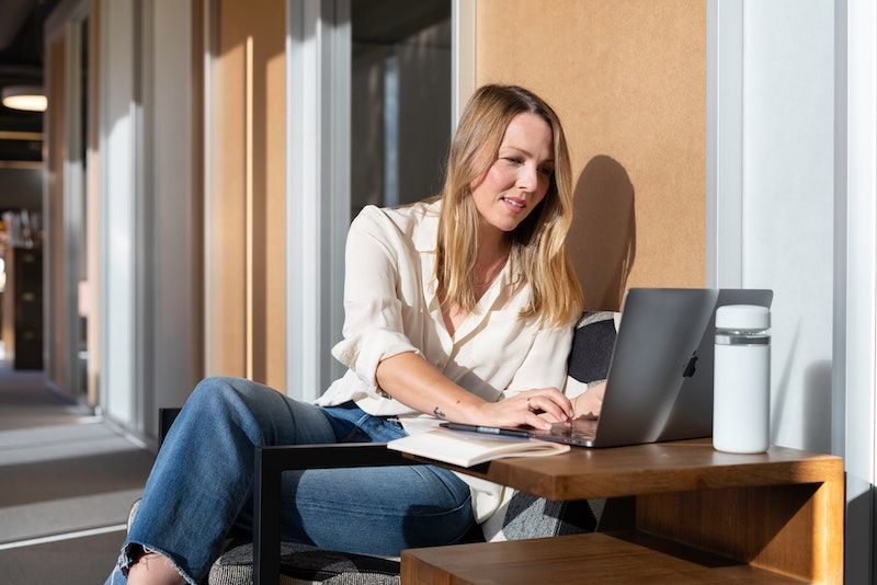 chica joven rubia con laptop al sol