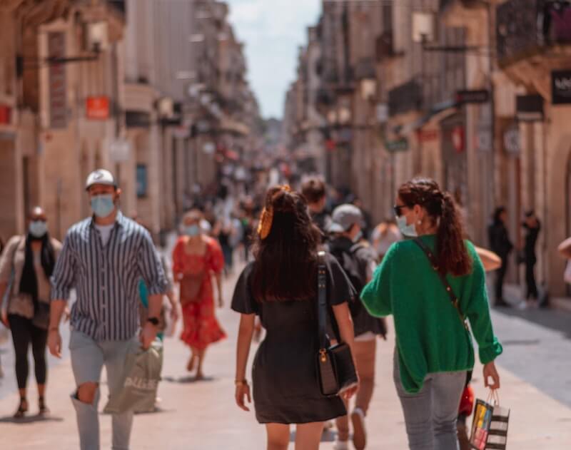 personas paseando en la ciudad con mascarilla