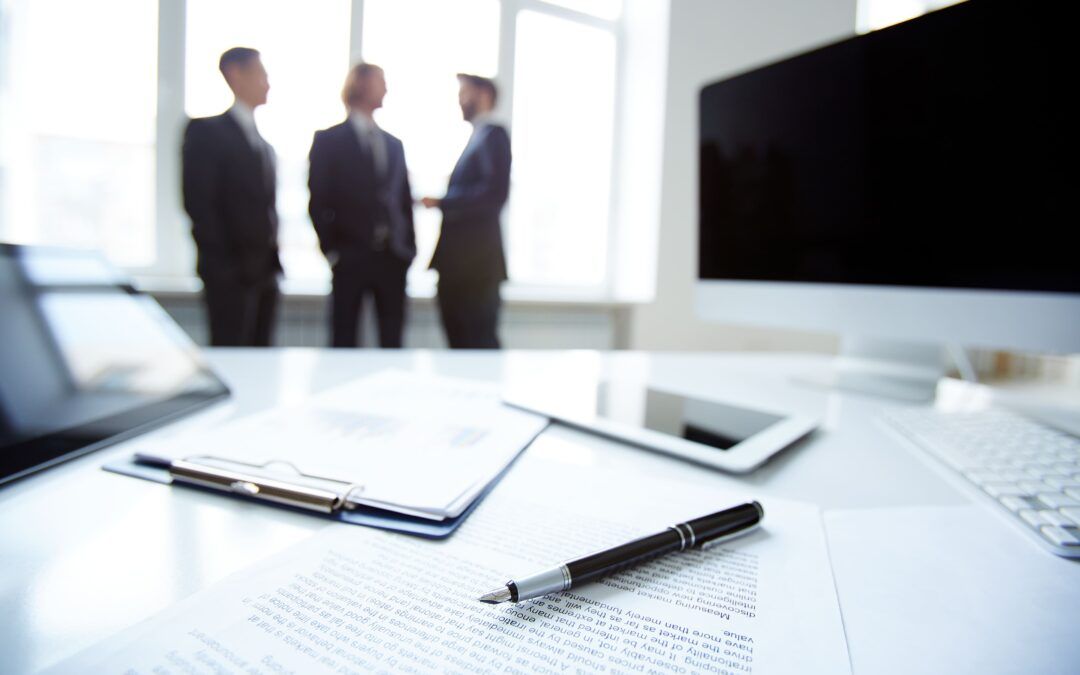 Oficina moderna con tres profesionales al fondo brindando asesoría empresarial a un cliente